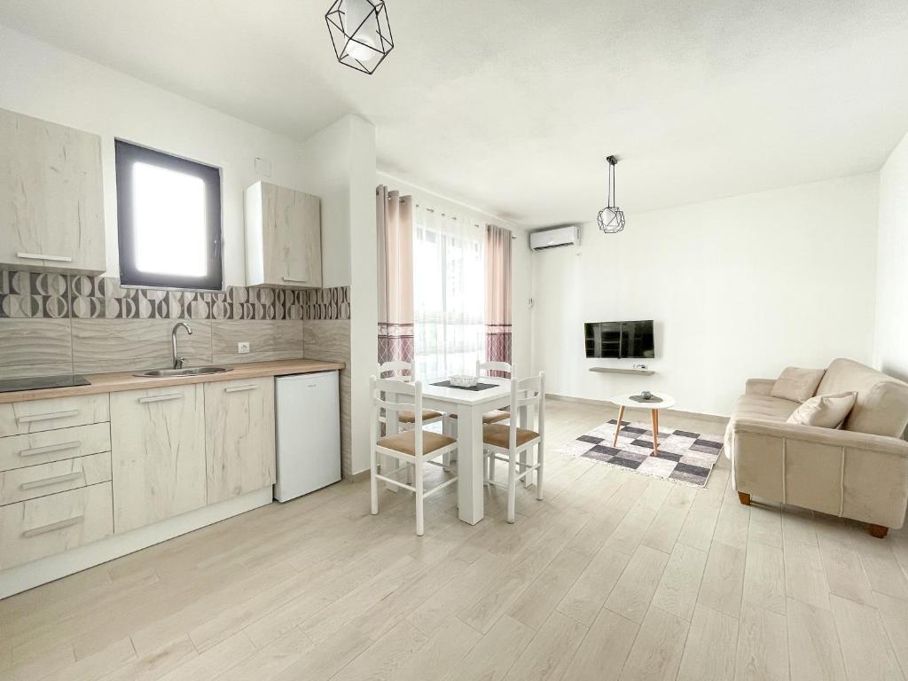 a kitchen and living room with a table and a couch at Rion Apartments in Ulcinj