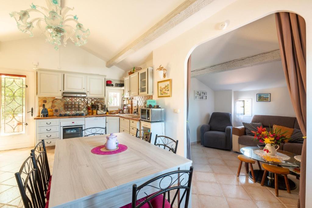 eine Küche und ein Wohnzimmer mit einem Tisch und Stühlen in der Unterkunft La Maximoise in Sainte-Maxime