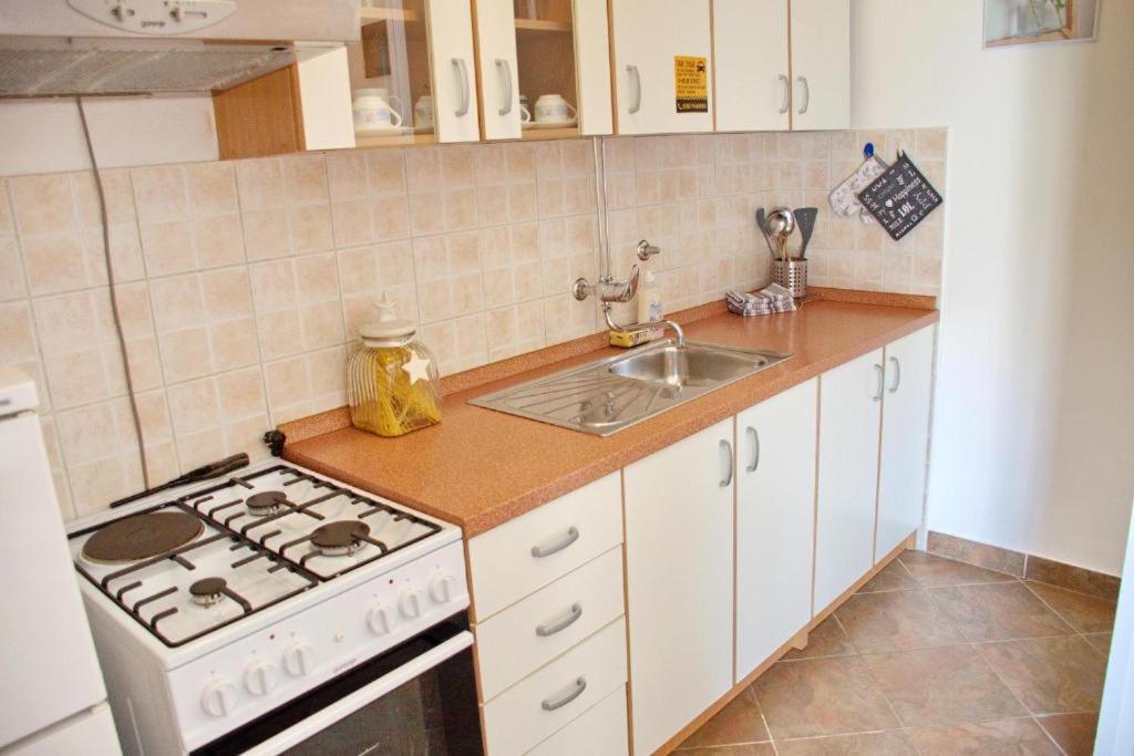 kuchnia z kuchenką i zlewem w obiekcie Two bedroom apartments Elvira w Novalji