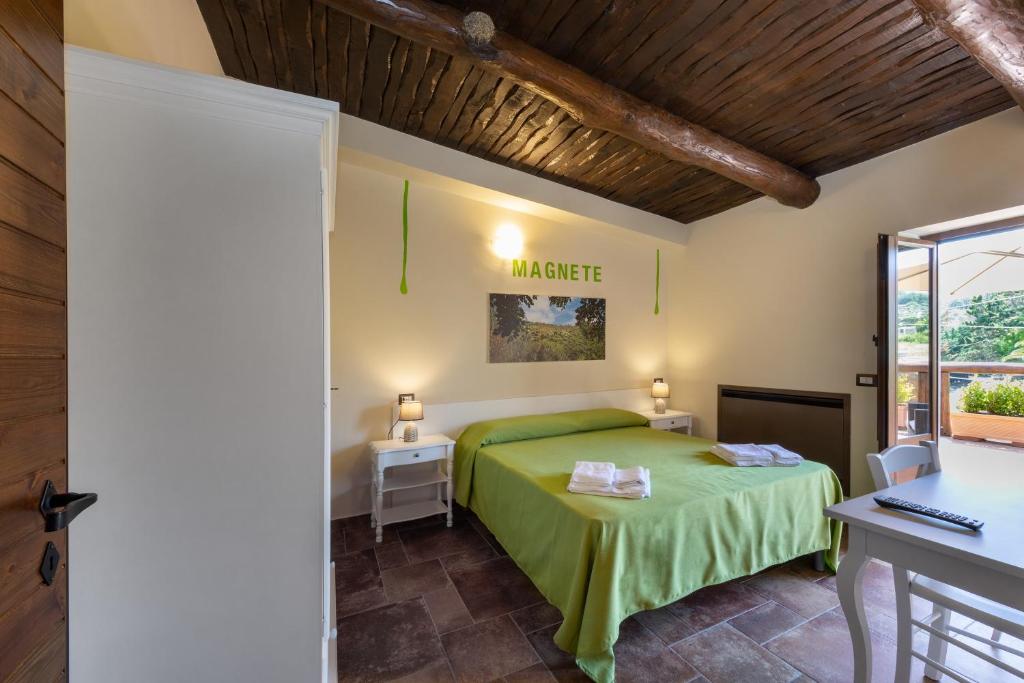 een slaapkamer met een groen bed en een bureau bij Residence Pietrabianca in Casal Velino