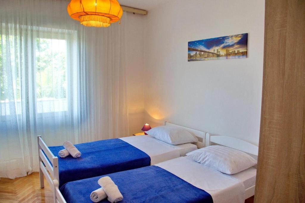sypialnia z dwoma łóżkami i ręcznikami na nich w obiekcie Two bedroom apartments Elvira w Novalji