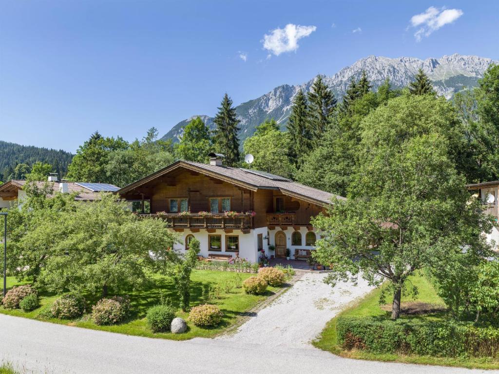 une maison dans les montagnes avec une allée dans l'établissement Appartement Melodie, à Scheffau am Wilden Kaiser