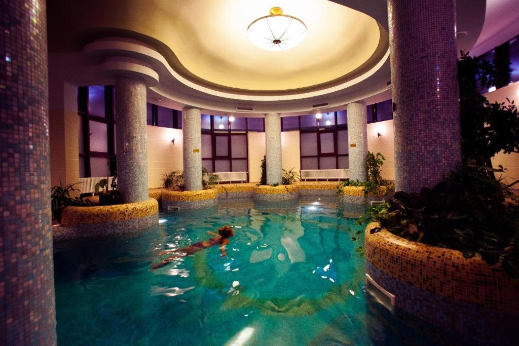 a person swimming in a swimming pool in a building at Denisa Boutique in Poiana Brasov