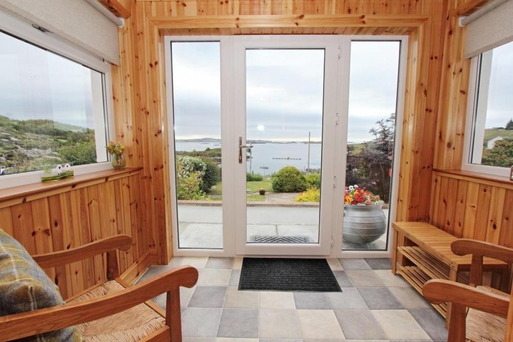 a room with a large window with a view of the ocean at Old Post Office in Tarbert