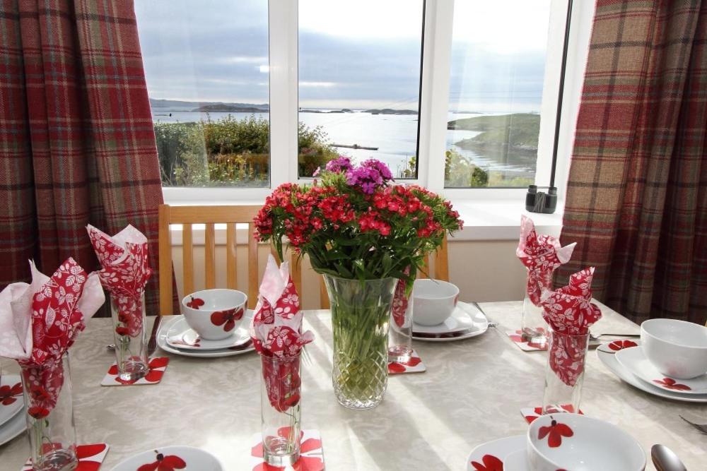 a table with a vase of flowers on top of it at Old Post Office in Tarbert