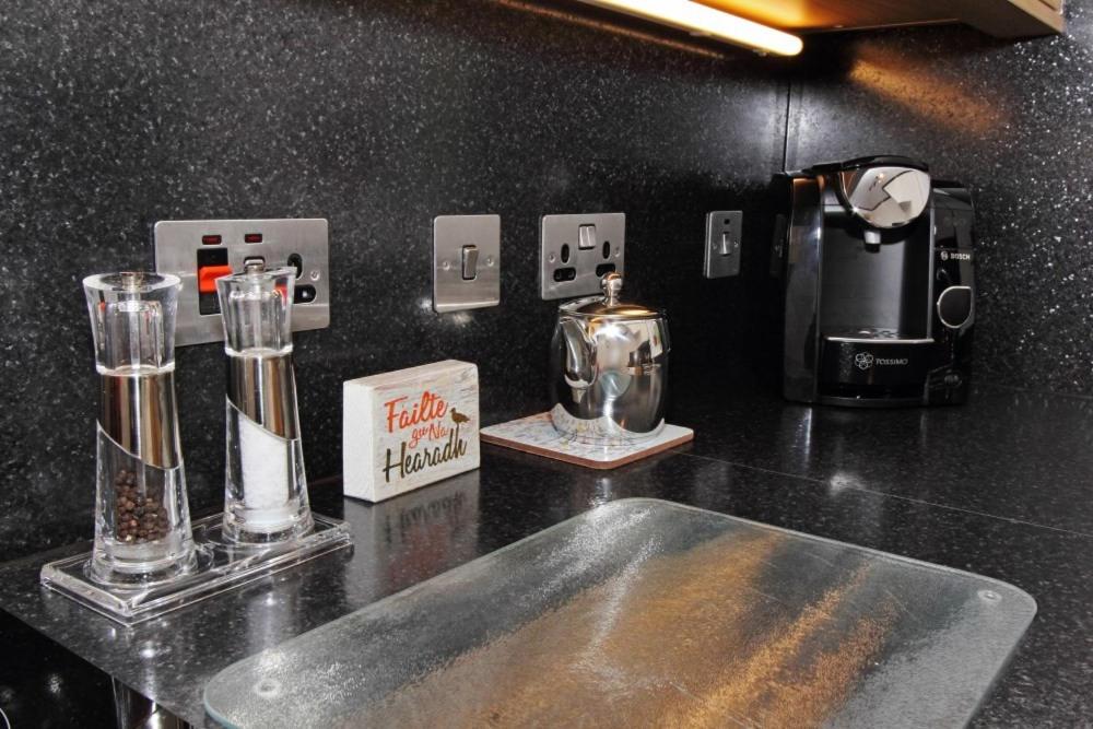 a black counter top with two glassutes on a counter top at Old Post Office in Tarbert