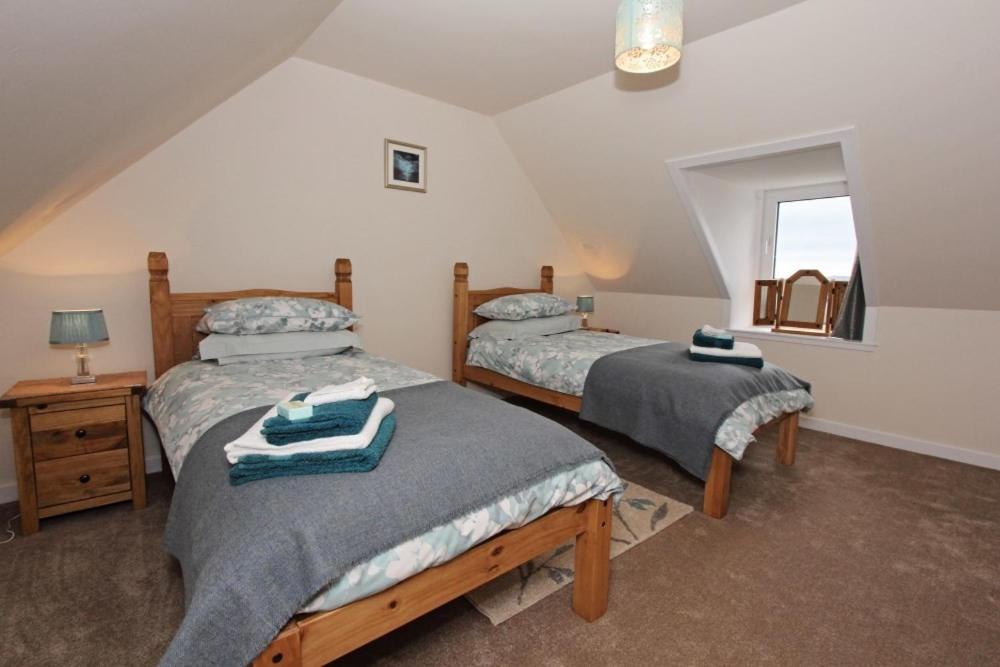a bedroom with two beds and a window at Old Post Office in Tarbert