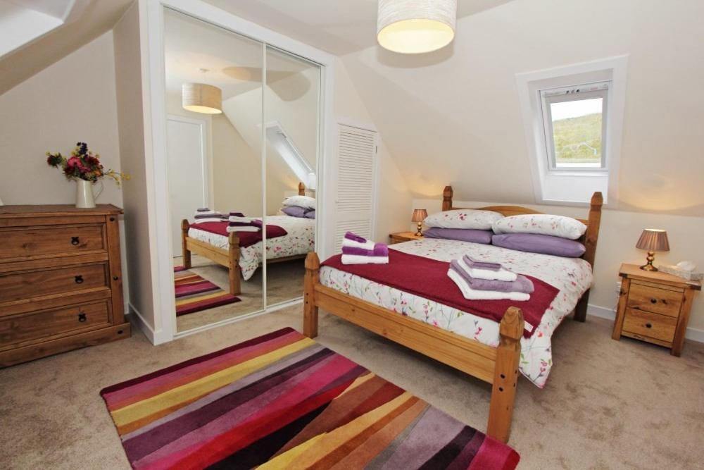 a bedroom with two beds and a mirror at Old Post Office in Tarbert