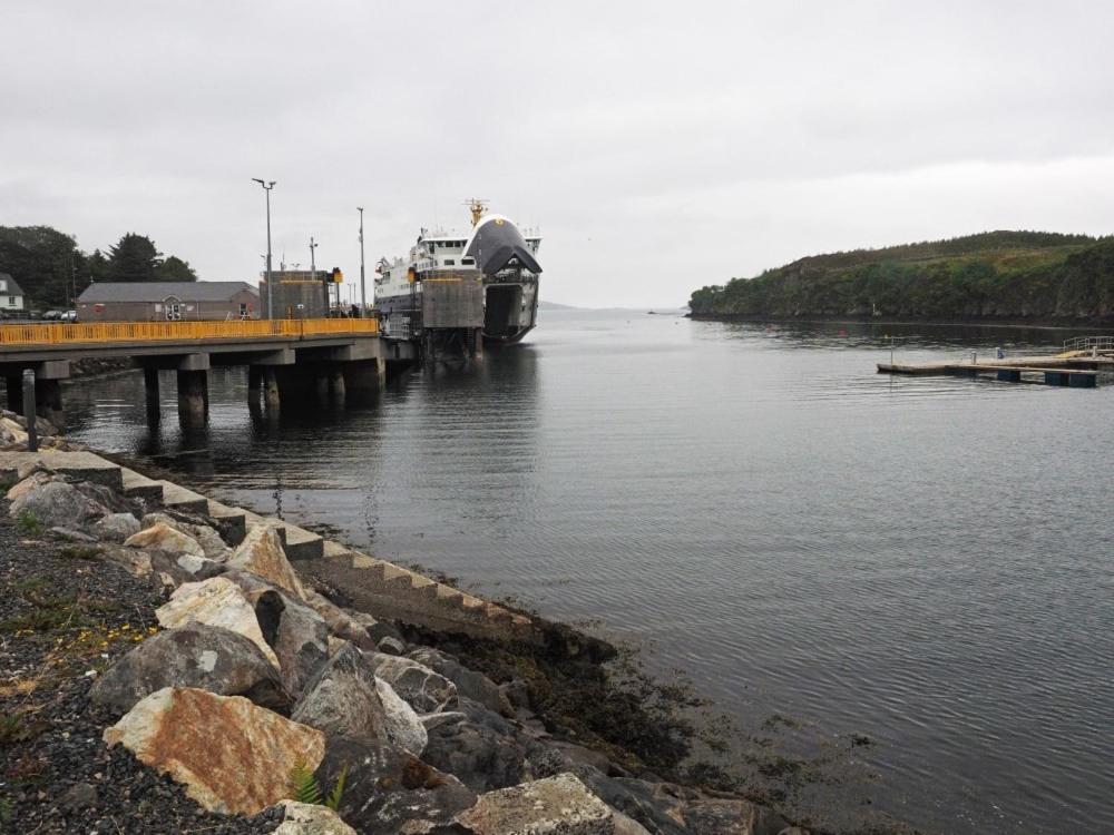 a boat is docked at a dock on the water at Old Post Office in Tarbert
