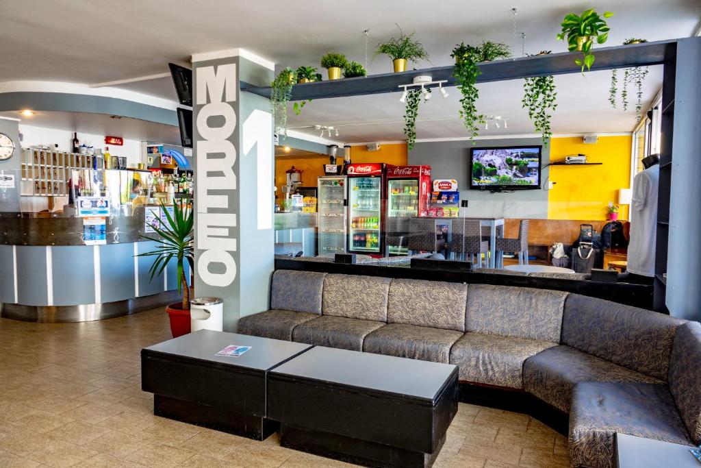 ein Wohnzimmer mit einem Sofa und einer Bar in der Unterkunft Hotel Morfeo - Young People Hotels in Rimini