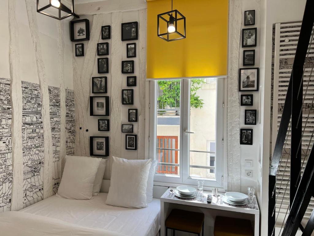 a living room with a white couch and a window at Studio Cléry in Paris