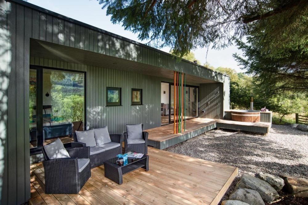 ein Haus mit einer Terrasse mit einem Sofa und Stühlen in der Unterkunft Am Bothan in Lochearnhead