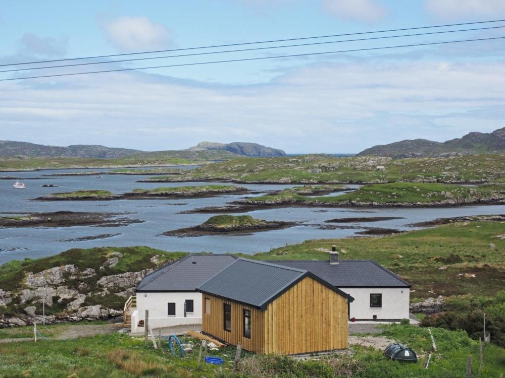 a house on a hill next to a body of water at Seaview in Eriskay