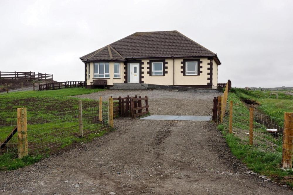 a small house in a field with a fence at Lingeigh in Pollachar