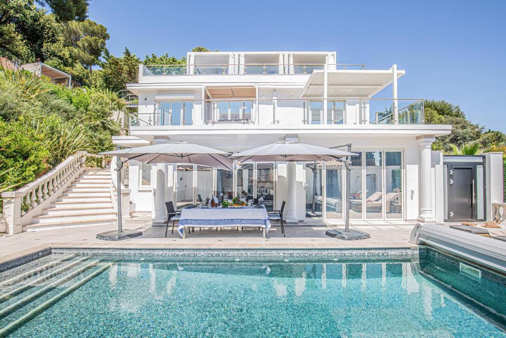 une maison avec une piscine, une table et des parasols dans l'établissement Villa Sandryon, à Antibes