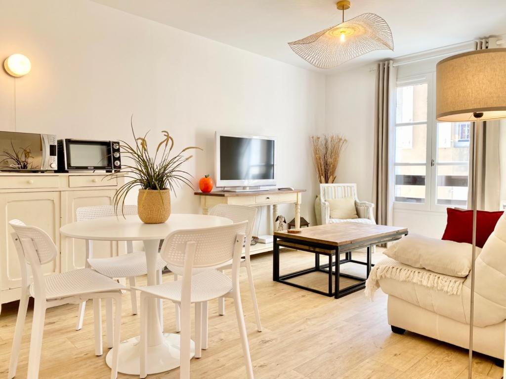 a living room with a white table and chairs at Appartement élégant avec vue sur le port in Saint-Martin-de-Ré