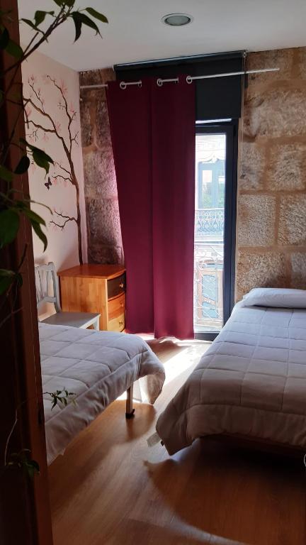 a bedroom with two beds and a window at Alfonso XII in Redondela