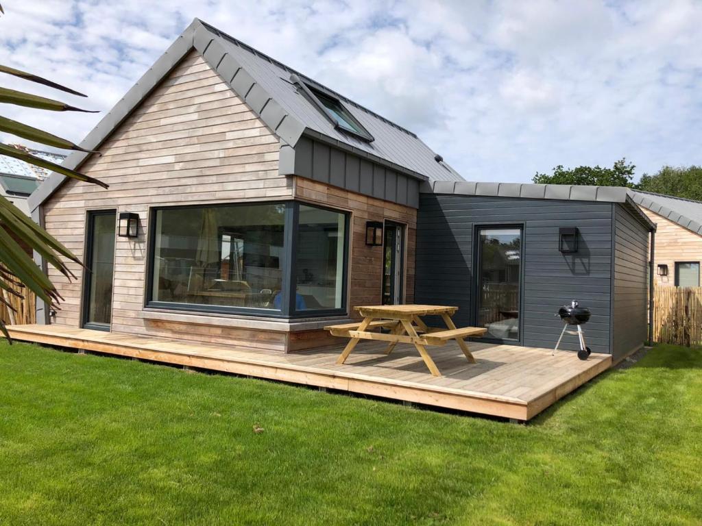 a tiny house with a picnic table on a deck at La cabine du bout du monde avec Mezzanine PL04, Tevennec - votre maison de vacances de haut standing in Crozon