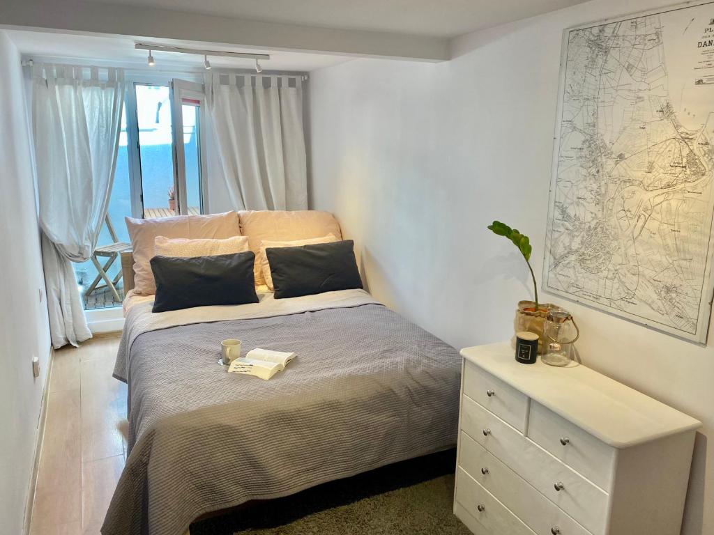 een slaapkamer met een bed en een dressoir met een kaart aan de muur bij Old Town Apartment in Gdańsk