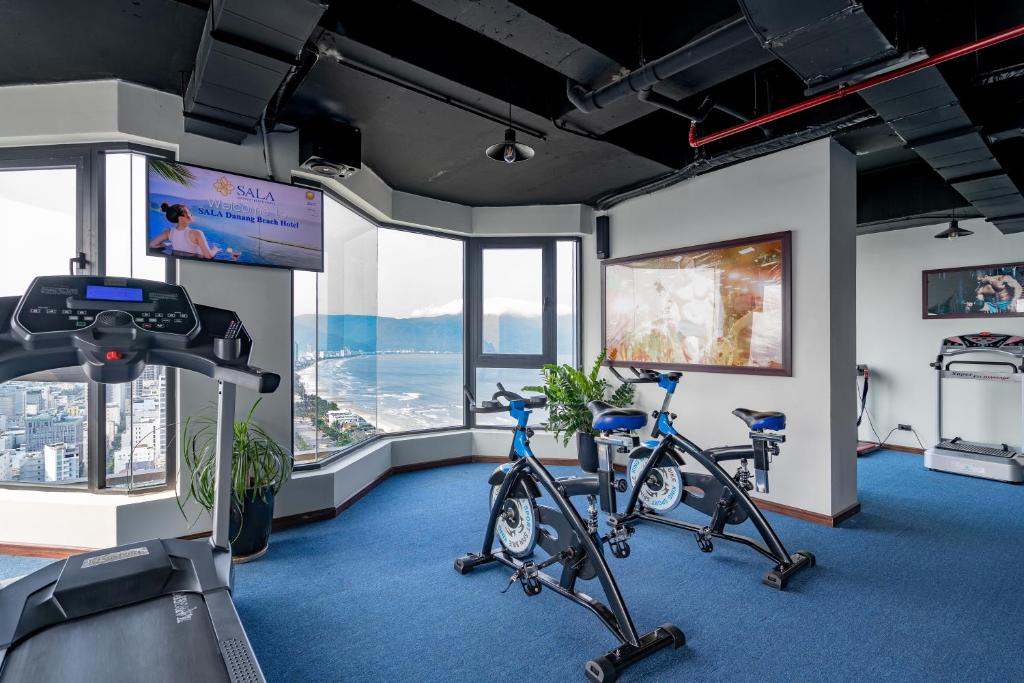 A compact hotel gym with cardio machines and ocean-facing windows.