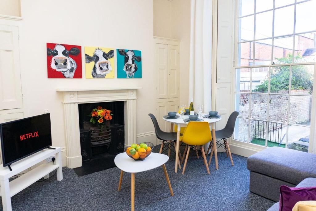 uma sala de estar com uma mesa e uma lareira em K Suites - Montpellier Apartments em Cheltenham
