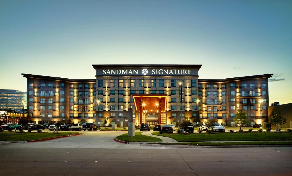 ein großes Gebäude mit einem Schild auf der Vorderseite in der Unterkunft Sandman Signature Plano-Frisco Hotel in Plano