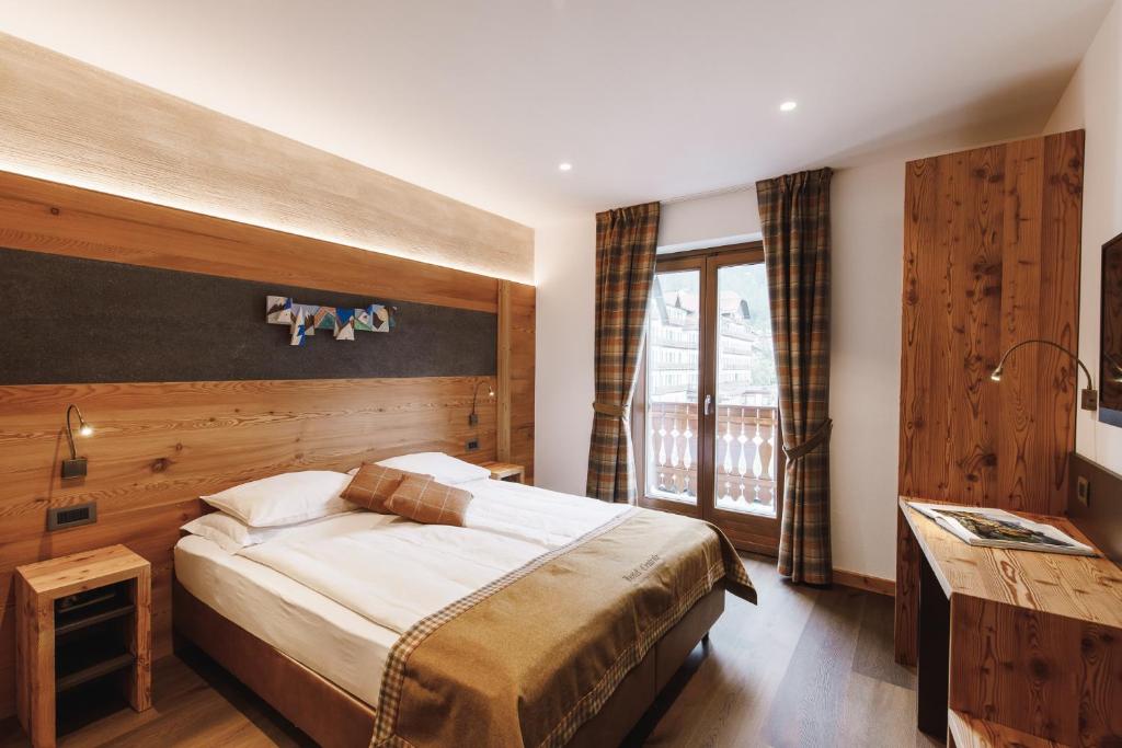 Un dormitorio con una cama grande y una ventana en Albergo Centrale, en San Martino di Castrozza