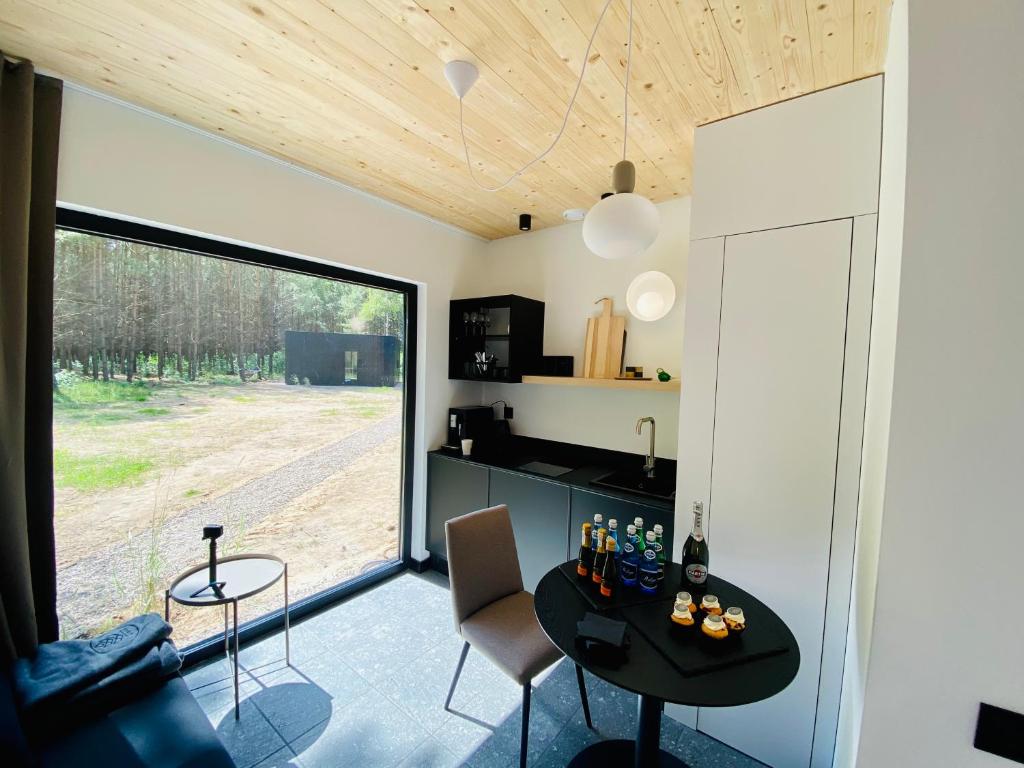 Una cocina y una sala de estar con mesa y sillas. en w lesie, en Skrwilno