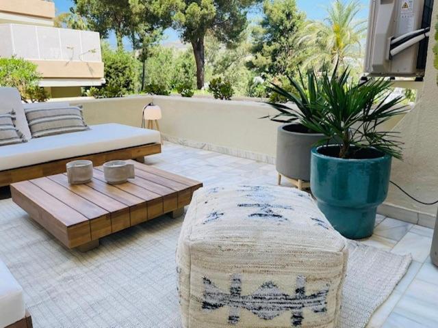un patio con una cama, un banco y una mesa en Lovely studio, en Marbella