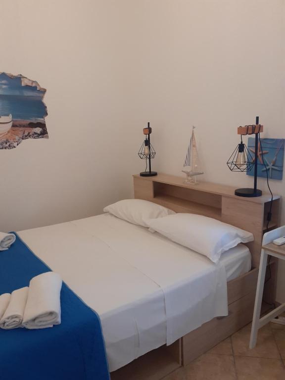 una camera con due letti e una mensola con prodotti per l'igiene personale di Casa du Piscature a Favignana