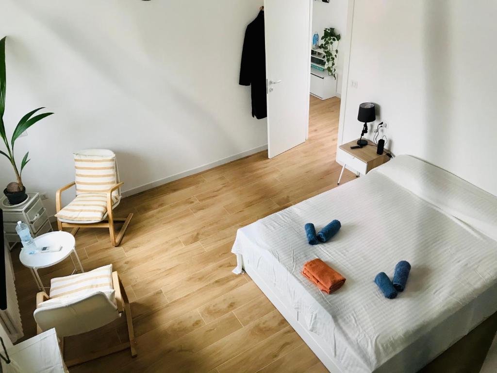 a bedroom with a white bed with two blue objects on it at Stanza e idromassaggio, con extra fee, in delizioso appartamento in Ferrara