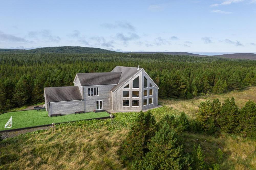 uma casa no topo de um campo com árvores em Constant & True Seasmhach agus Dileas em Sollas