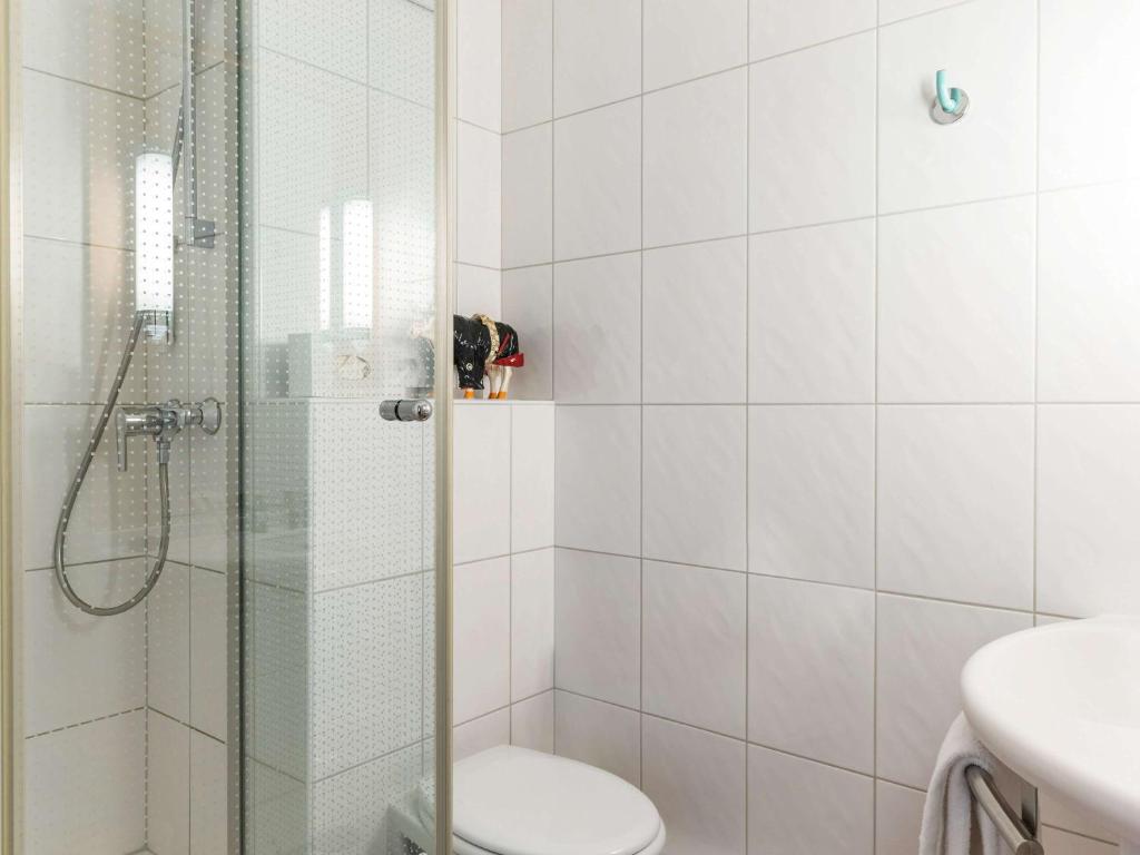 e bagno con doccia, servizi igienici e lavandino. di Ibis Sion a Sion