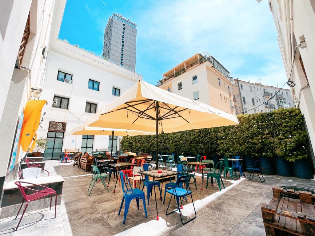 a patio with tables and chairs and an umbrella at NeapolitanTrips Hotel in Naples