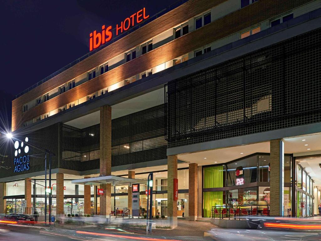 um edifício com um hotel tbs à noite em ibis Poços de Caldas em Poços de Caldas