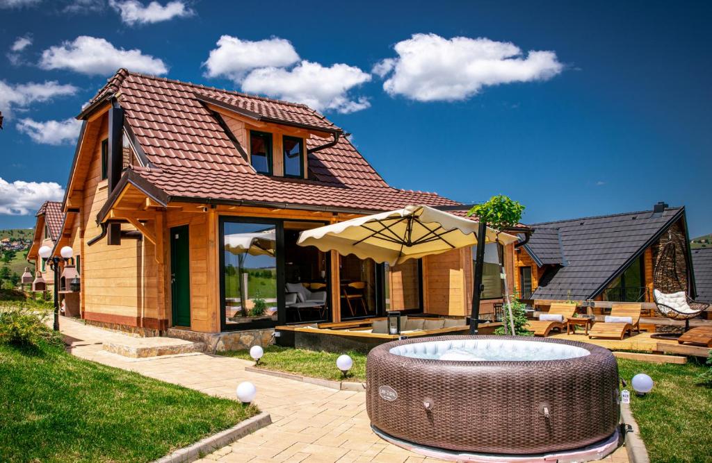 a house with a hot tub and an umbrella at The Crown Lodge in Zlatibor