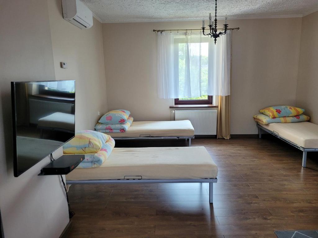 a room with three beds and a window at Andrychów Apartment in Andrychów