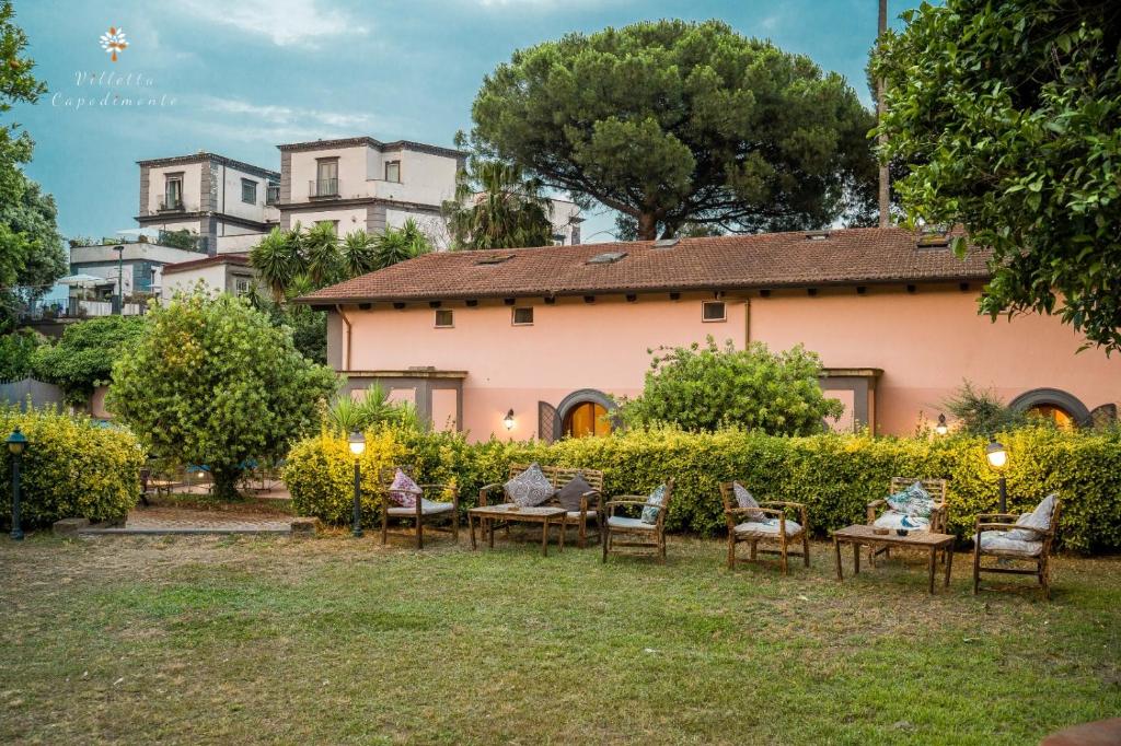 un cortile con tavoli e sedie di fronte a una casa di Villetta Capodimonte a Napoli