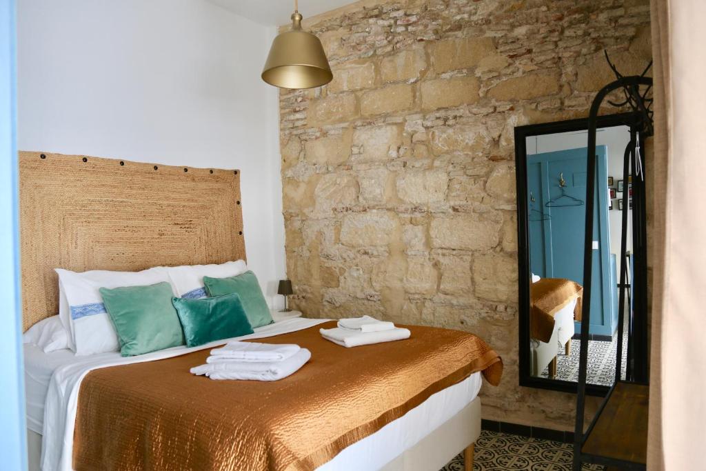 een slaapkamer met een bed met een spiegel bij Entre Bodegas Jerez in Jerez de la Frontera