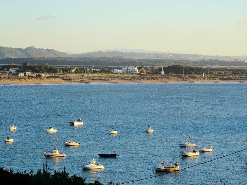 a group of boats in a large body of water at Lighthouse - House with amazing sea views in São Martinho do Porto