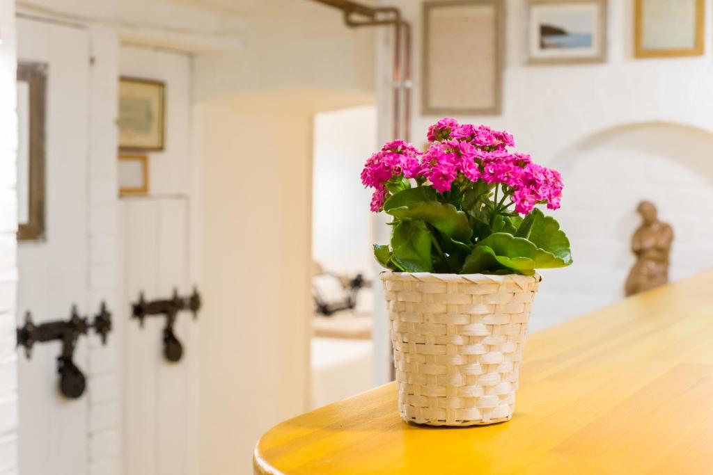 eine Vase mit rosa Blumen auf einem Tisch in der Unterkunft Ádám Apartman in Balatonföldvár