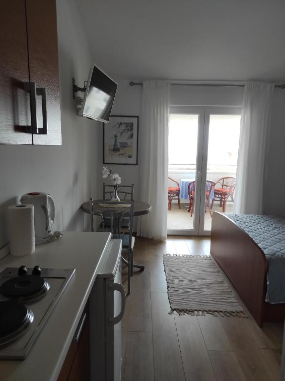cocina y sala de estar con cama y mesa en Apartments Marija, en Makarska