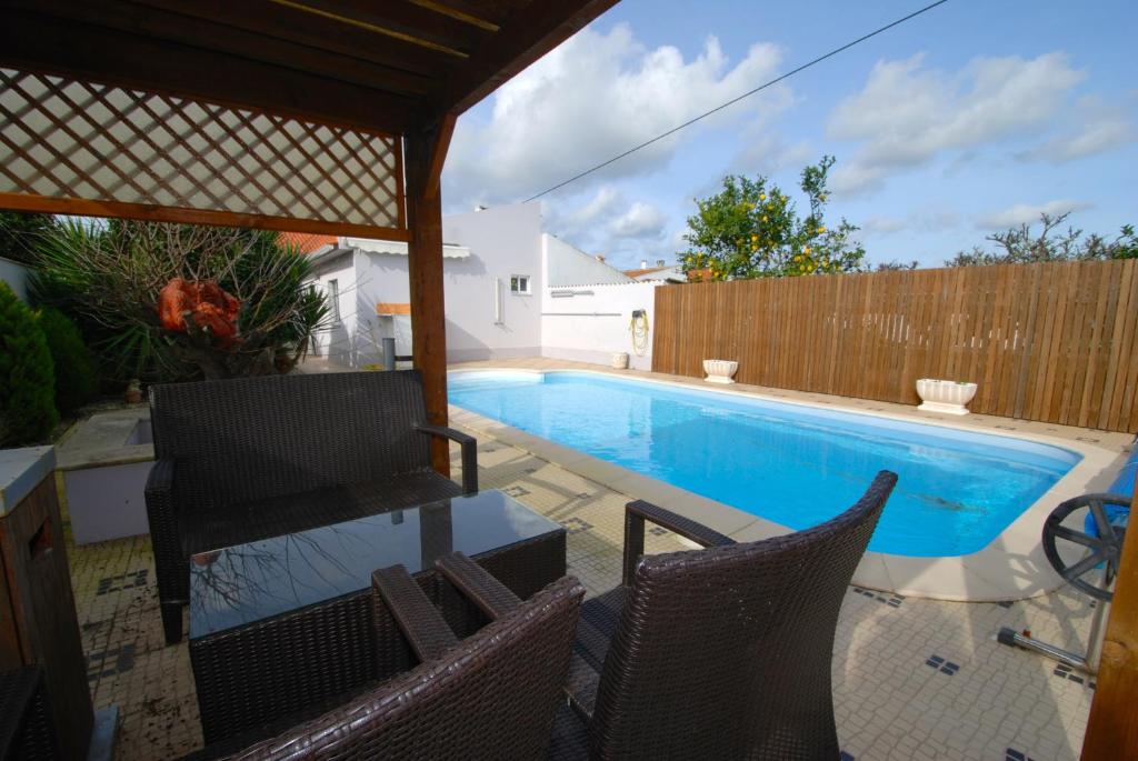 una piscina con 2 sillas junto a una valla en Laranjeira - House with private garden and pool, en Alfeizerão