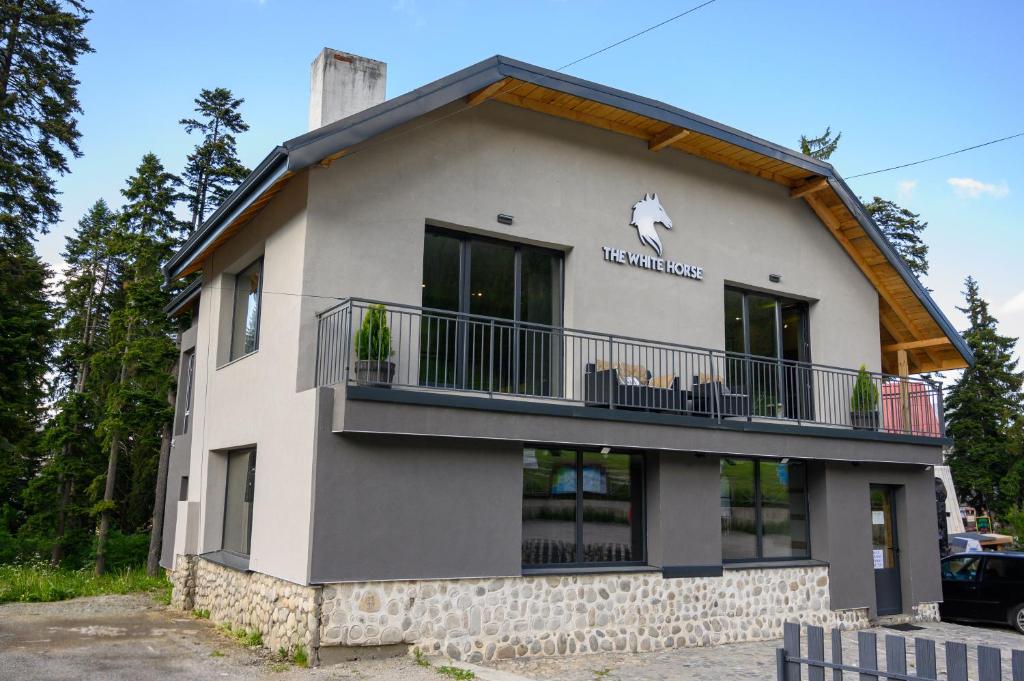 a building with a balcony on the side of it at The White Horse Apartmens in Borovets