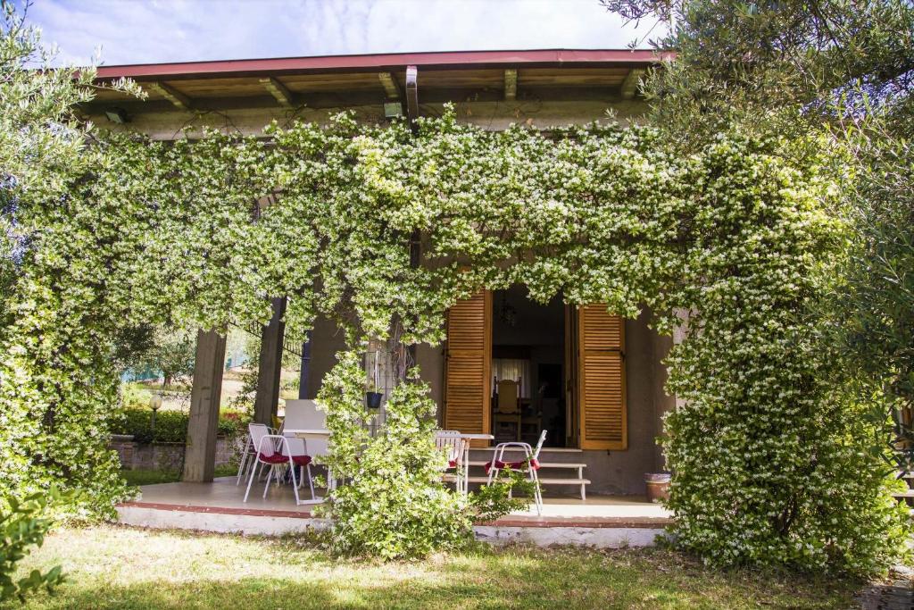 a house with a table and chairs under a hedge at Casa Mia -Per Sentirti a Casa Tua - Giardino, Parcheggio e Jacuzzi in Perugia
