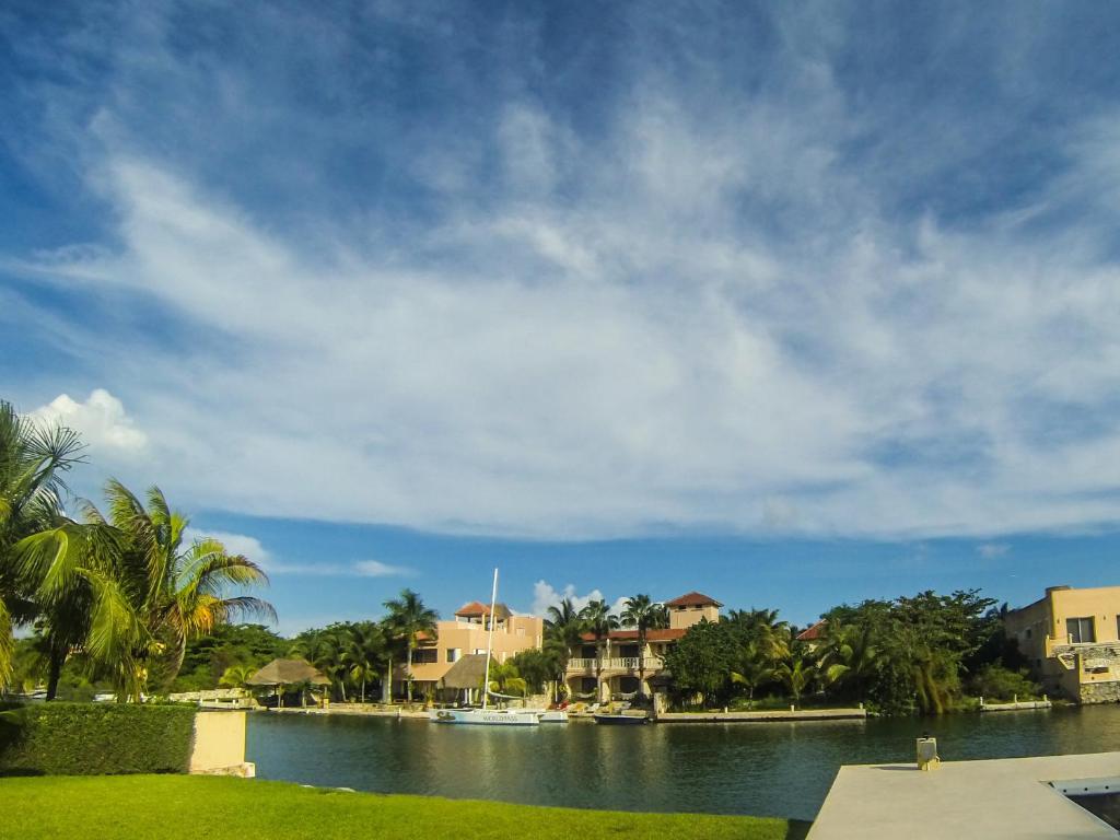 a body of water with houses and palm trees at Chez Waffle Hotel in Puerto Aventuras