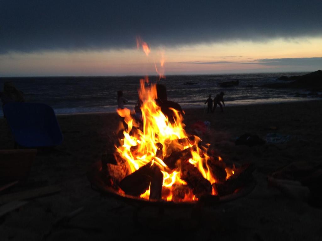 a fire pit on the beach at sunset at Aqua Shack at Pure Shores Retreats in Newquay