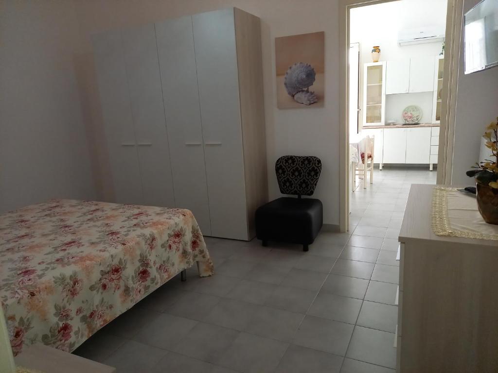 een slaapkamer met een bed en een stoel in een kamer bij Casa Giada in Porto Cesareo