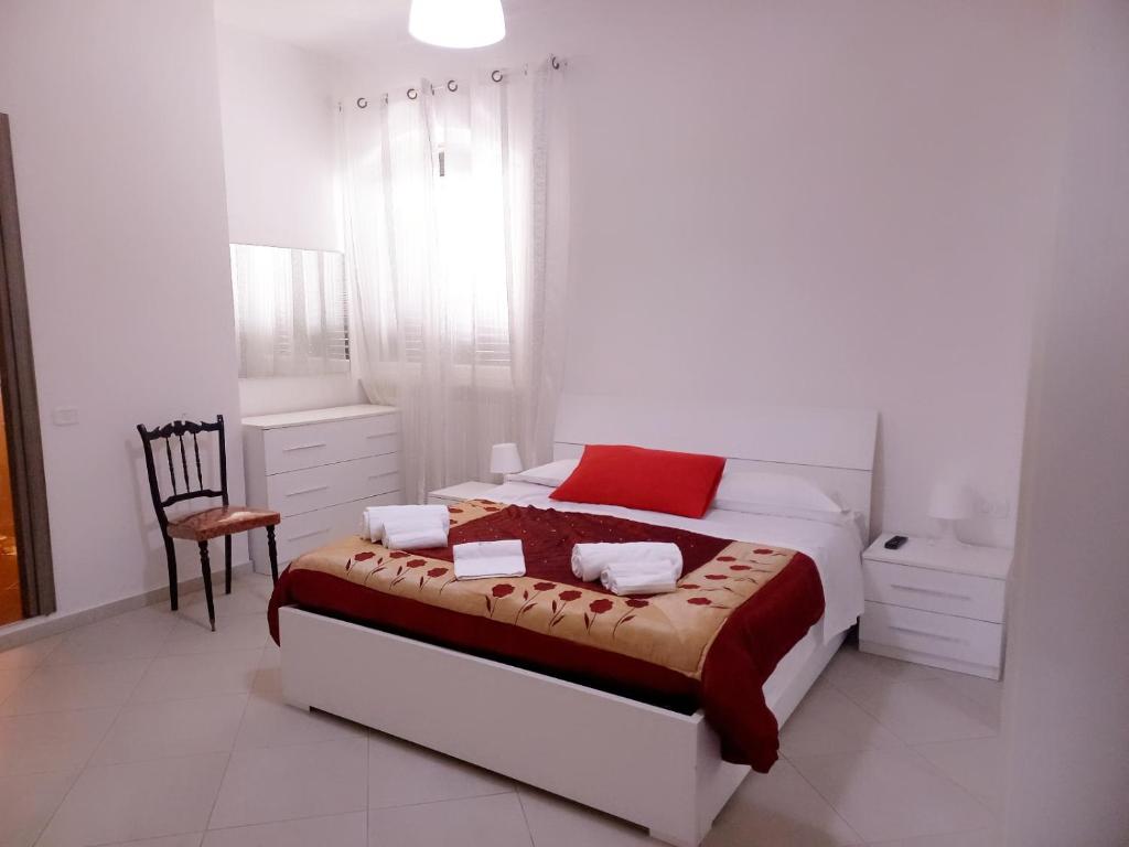 a white bedroom with a bed and a chair at Casa Eraldo in Castellaccia