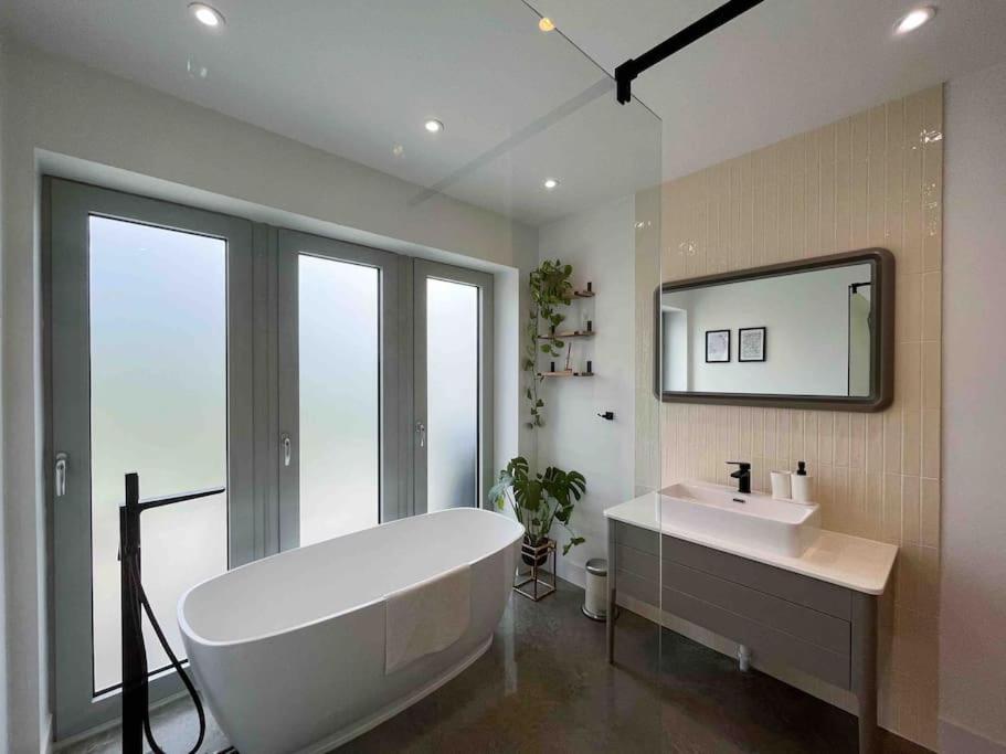 uma casa de banho com uma banheira grande e um lavatório em Lodge Barn Annexe 